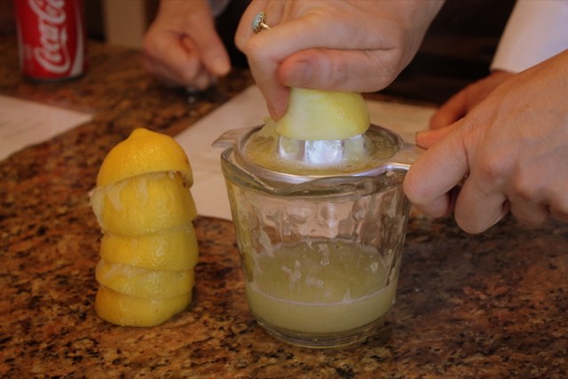 A lemon being squeezed by hand
