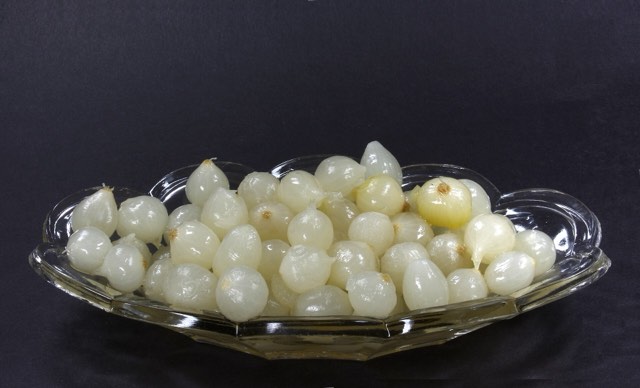 Little silver-skin pearl onions heaped in a cut-glass dish