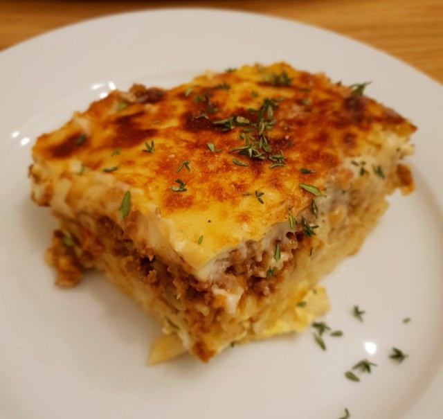 A square of pastitsio showing pasta, meat, and crema layers